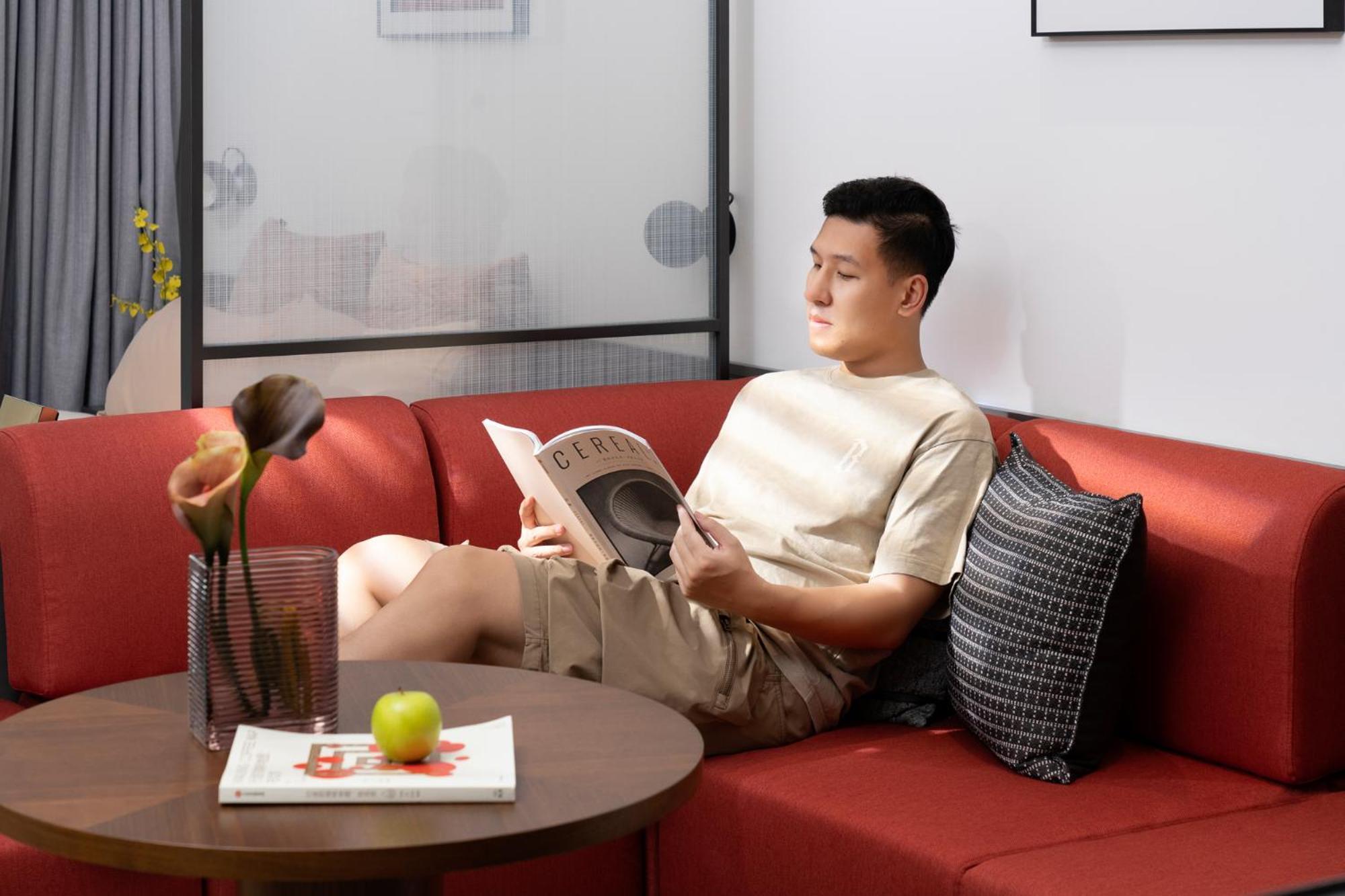 Base-Beijing Wangfujing Serviced Apartment- In Hutong &Bike Rental &Close To Forbidden City, Tian'Anmen Square &Subway Nearby &Free Coffee &Washing Machine,Kitchen &Restaurant Discount &English Speaking &High Speed Free Wifi Pequim Exterior foto A man reading a book on a sofa